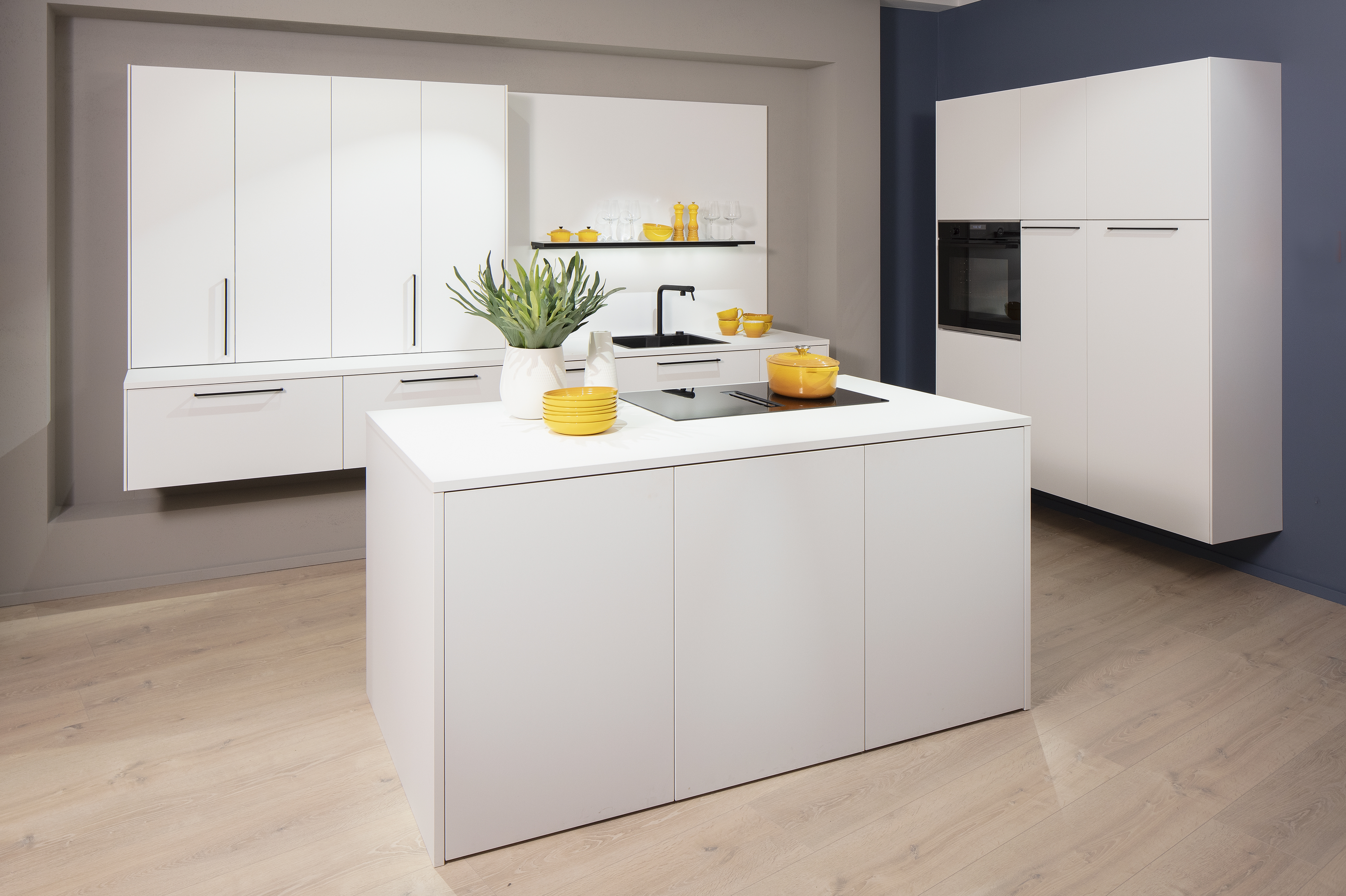 Häcker-Küche in Kristallweiß mit Insel und Schrankwänden. 