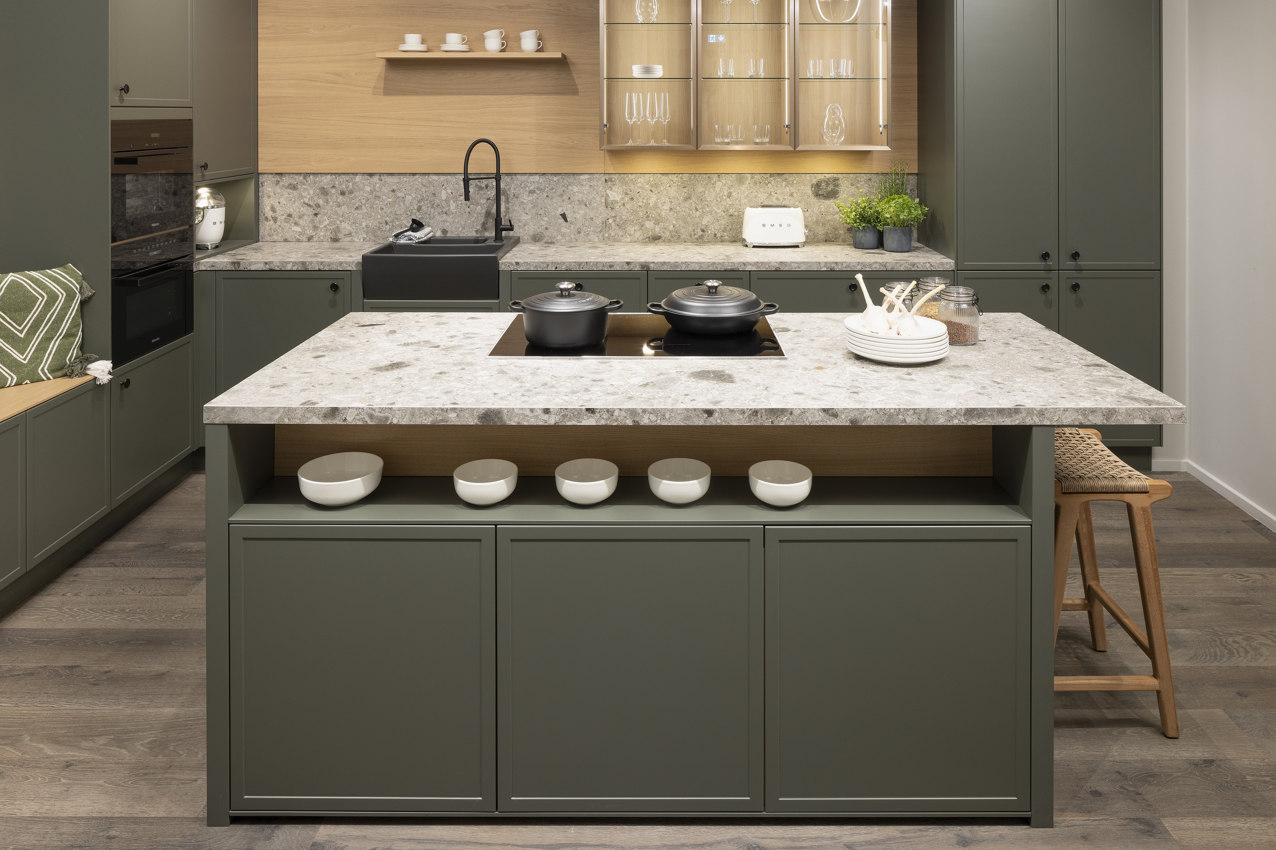 APL: Iseo Gris (Keramik) 40 mm Front: AV 5085 NCS S Mattlack (7005-G50Y)  Front 2: Feineiche-natur Repro Korpus: 2085 Designkorpus Feineiche-natur Griff: 113 Metall Schwarz-matt Geräte: Miele Armatur: Blaupunkt Spüle: Systemceram   Features:Keramik-Arbeitsplatte, Landhausküche modern, Nischenrückwand in APL-Material hochgezogen, Wandverkleidung in Vitrinen Material, Backofenkombi mit Kompaktbackofen, Sitzbank in Nischenmaterial, Spülbecken als Waschtisch aufgesetzt (Landhaus).