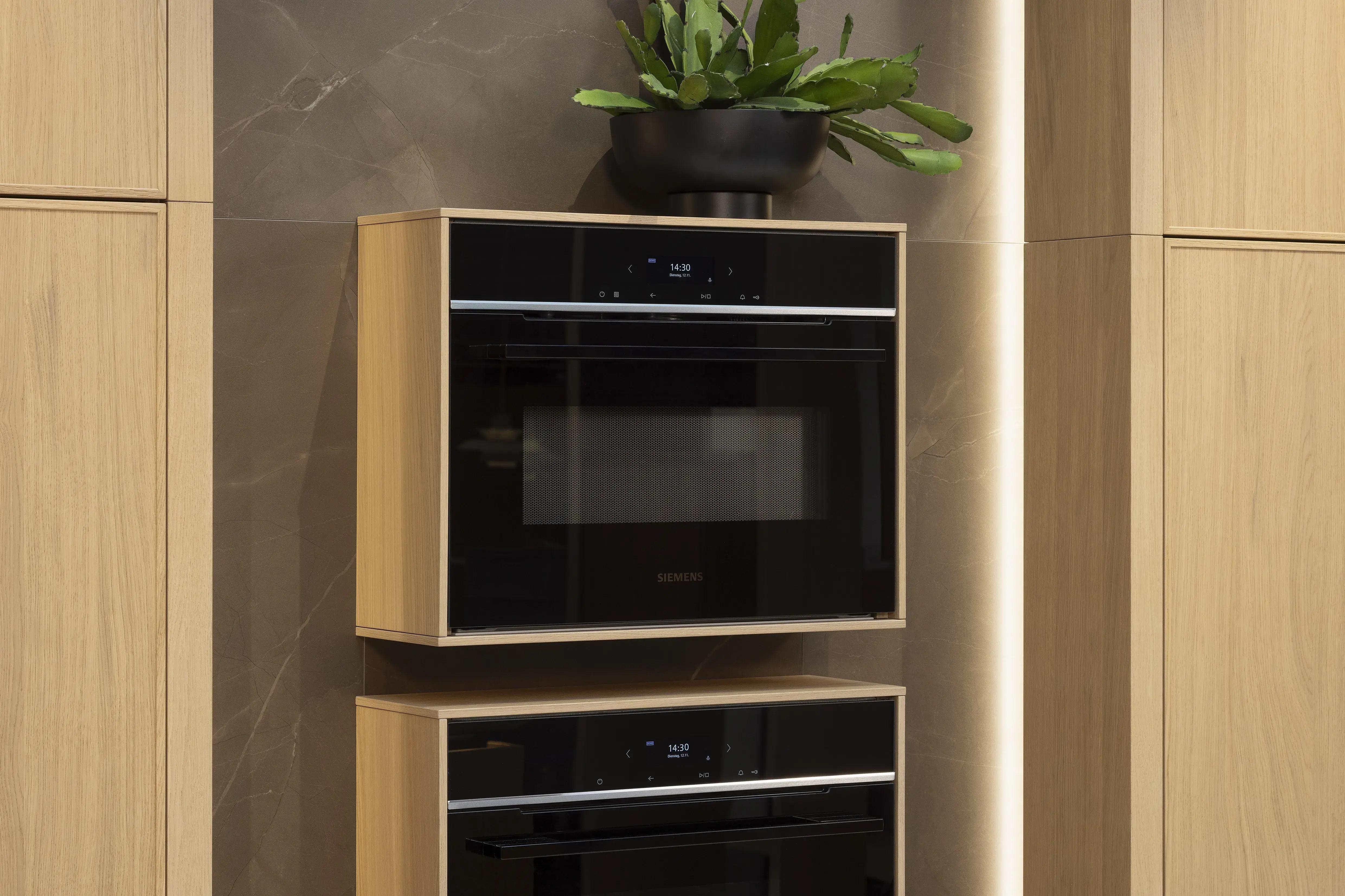 APL: Pulpis (Keramik) 25 mm Front: AV 6085-GL Eiche-elegant Echtholzfurnier (PURemission) Korpus: 2085 Designkorpus Feineiche-natur Griff: Kehlleiste 355 Schwarz matt Geräte: Siemens  Armatur: Gessi Spüle: ?  Features: neue Oberfläche Wiener Geflecht in Echtholzfurnier, Oberflächenmix, Waschbecken (Spülstein) in APL-Material, schwebende Arbeitsplatte durch Lichtleiste, APL abgekantet (schwebend), Backöfen in Wand eingekoffert, 3 Materialfarben.